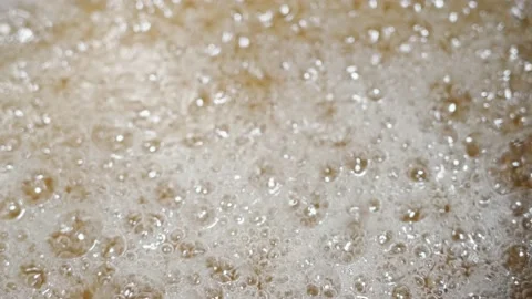 Close-up bubbles of liquid caramel. caramel boils in a saucepan on the stove Stock Footage 196920740