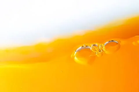 Close-up of bubbles in orange liquid with white background Stock Photos
