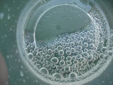 Close-Up of Bubbles in a Plastic Cup with Carbonated Water Stockfoto's
