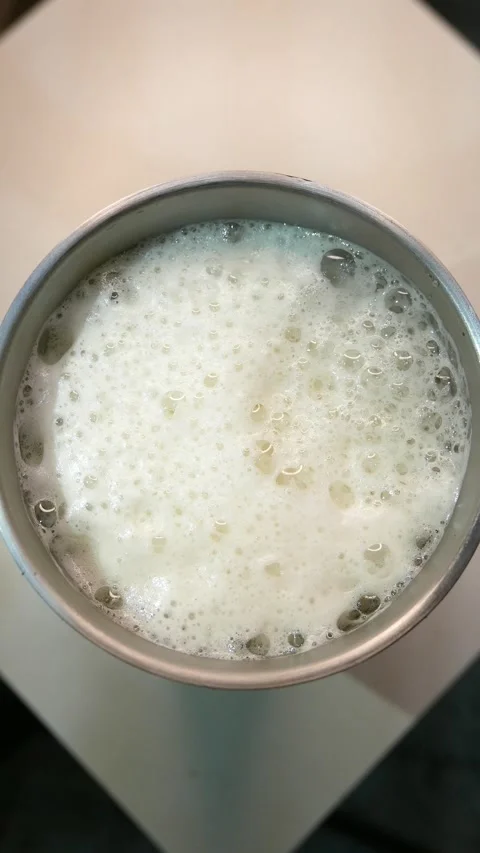A close-up of bubbles slowly bursting in beer foam. A glass of beer on the table Stock Footage 333104665