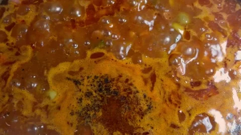 Close-up of bubbling thick sauce with vivid orange tones. Stock Footage 323114668