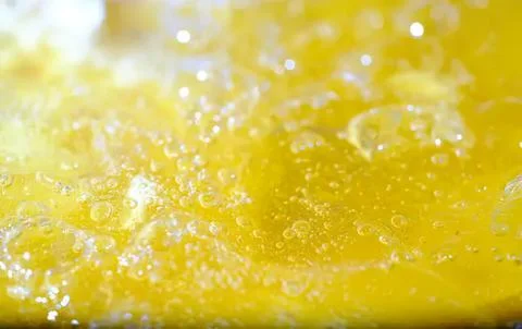 Close-up of bubbling yellow liquid with foam and shine Stock Photos
