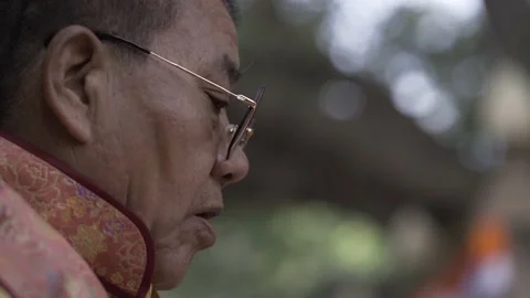 Close up of a buddhist monk with sunglasses praying and meditating Stock Footage 229848825