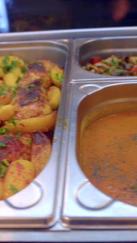 Close-up buffet pans with steamed rice, tomato stew and roasted potatoes under Stock Footage 336534568