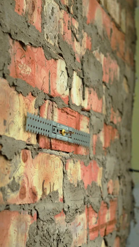 Close up of builder hand fixing metal perforated suspension bracket for drywall Stock Footage 330356790
