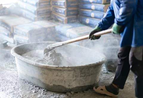 Close-up of a builder preparing concrete mix in a plastic trough with cemen.. Stock Photos