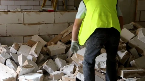 Close up of builder removing breeze block and rubble from building site Stock Footage 112609466