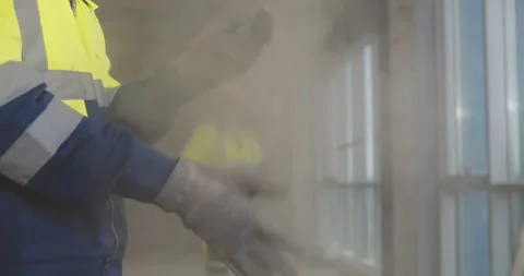 Close up of builder shaking off dust from gloves at construction site Stock Footage 153407800