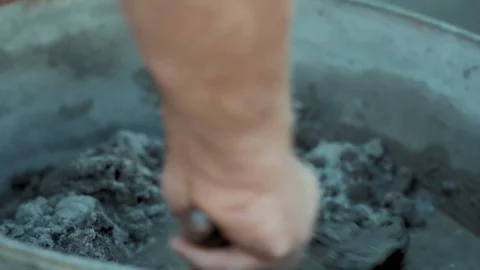 Close-up, Builder's Hand Kneads Solution from Cement in Iron Barrel Stock Footage 121125050