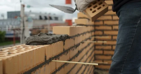 Close-up of builder's hands at work, smoothly put bricks in masonry, builds wall Stock Footage 116813181