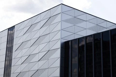 Close-up of building with triangular pattern and round openings on wall and Stock Photos
