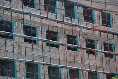 Close up on a building under construction and scaffolding. Stock Photos