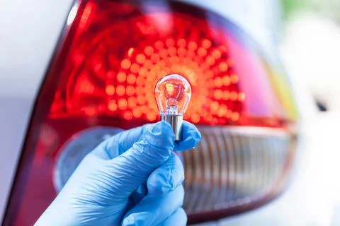 Close up of a bulb with car tail light in the background Stock Photos