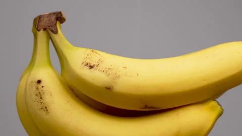 Close Up Bunch Of Fresh Yellow Bananas Rotating On White Background 4K Stock Footage 322123750