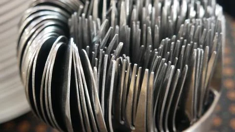 Close-up of a bunch of metal spoons on a table. Food equipment in restaurant Stock Photos