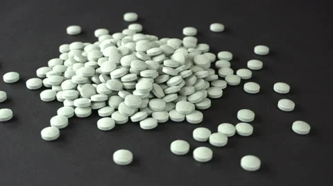 Close up of a bunch of pills rotating on a black background. Seamless loop Stock Footage 66857529