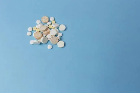 Close up of a bunch of tablets different kinds lay down a light blue background Stock Photos