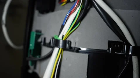 Close-up of bundled electrical wires secured with cable clips inside equipmen Vidéo 338319358