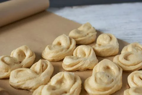 Close-up of buns on baking paper with rolling pin. Stock Photos