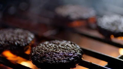 Close up of burger chops on grill with fire flames, slow motion Stock Footage 92690297