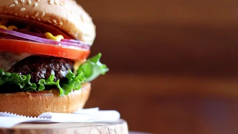 Close-up of burger with copyspace rotating on wooden texture Stock Footage 87769269