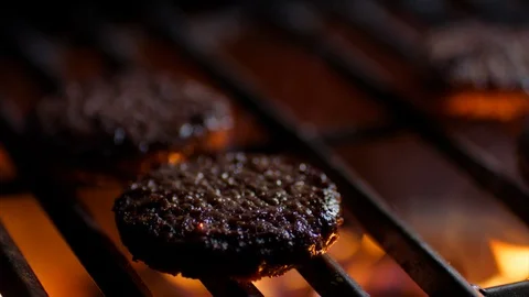 Close up of burger cutlets on grill with fire flames, slow motion Stock Footage 92688037
