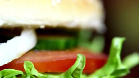 Close-up of burger with juicy tender beef meat and vegetables, turning, Video stock 336579019
