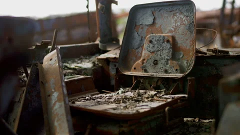 Close-Up of Burned Tractor Seat Rusting in Junkyard Stock Footage 305309440
