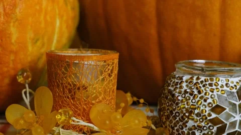 Close-up of a burning candle against the backdrop of pumpkins. Stock Footage 210177716