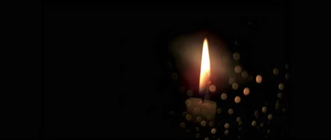 Close-up, burning candle on black background, behind glass with bokeh reflection Stock Footage 237712436