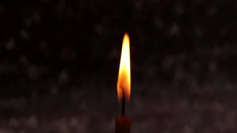 Close-up of a burning candle flame against a background of blurred raindrops Stock Footage 310719695