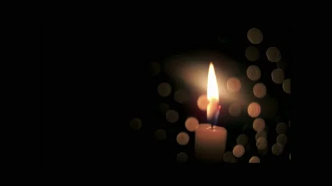 Close-up, burning candle wick behind glass with drops in bokeh, on black Stock Footage 237065672