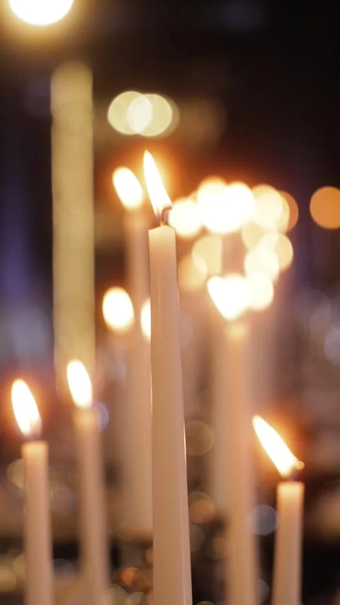 A close-up of burning candles with soft, warm bokeh lights in the background Stock Footage 305784140