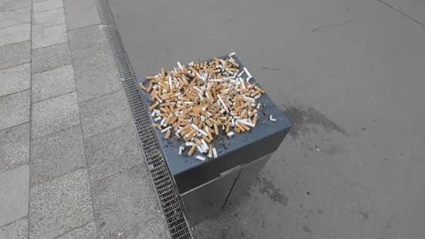 Close-Up Of burning  Cigarette In public Ashtray nicotine addiction habit smoke Stock Footage 232067504