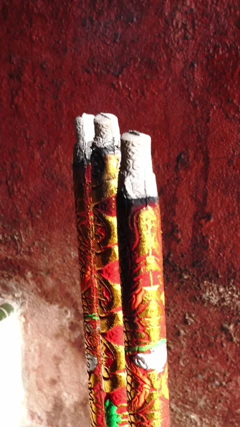 Close-up of burning incense sticks with embossed red and gold patterns against Stock Footage 345722668