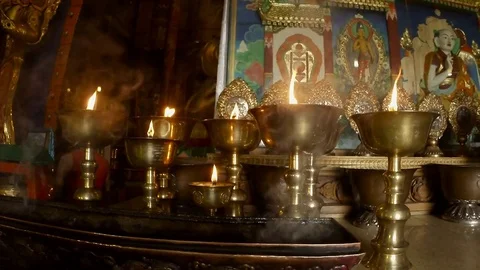 Close-up of the burning lights in a Buddhist temple, statues and smoke, in Stock Footage 81815685