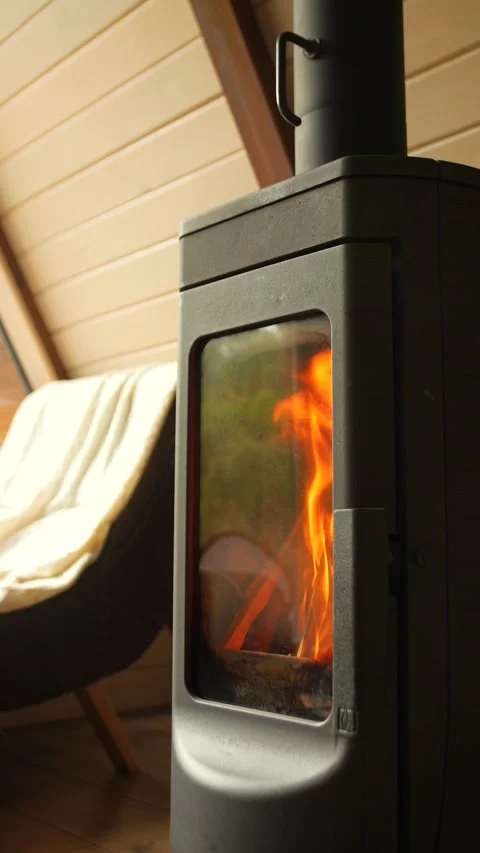 Close-up of burning logs in a fireplace in A-frame house. Vertical video. Stock Footage 311048623
