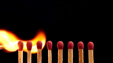 Close up burning match setting fire to a row of unlit matches Stock Footage 149423307