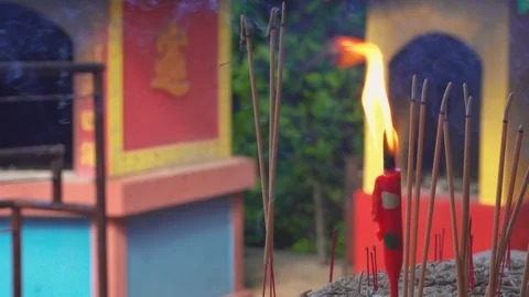 Close up burning red candle Incense sticks and smoke from incense burning Stock Footage 122667158