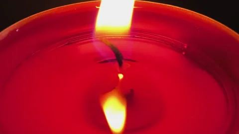 Close-up of a burning red tealight candle with a bright flickering flame Stock Footage 343629442