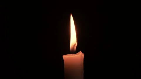 Close-up burning single candle flame isolated on black background, 4K video Stock Footage 151062946