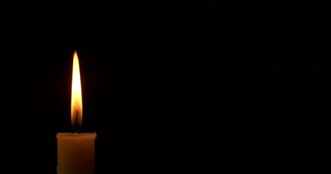 Close-up burning single candle flame isolated on black background, 4K video Stockbeeldmateriaal 160792433