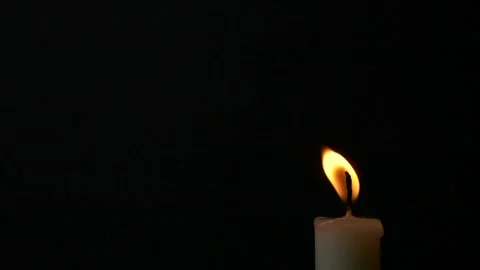 Close-up burning single candle flame isolated on black background, 4K video Stock Footage 165580045
