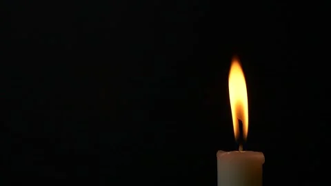 Close-up burning single candle flame isolated on black background, 4K video 動画素材 166597170