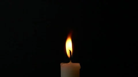 Close-up burning single candle flame isolated on black background, 4K video Stock Footage 166933718