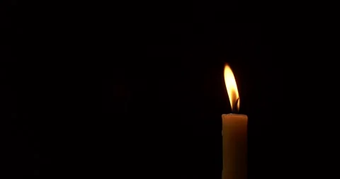 Close-up burning single candle flame isolated on black background, 4K video Video stock 167299172