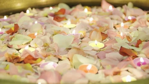 Close-up of burning tealight candles floating in water with rose petals. Diwali. 스톡 동영상 321816686