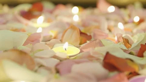 Close-up of burning tealight candles floating in water with rose petals. Diwali. Stock Footage 321816692