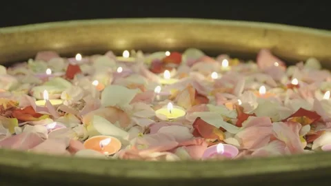 Close-up of burning tealight candles floating in water with rose petals. Diwali. Stock Footage 321816713