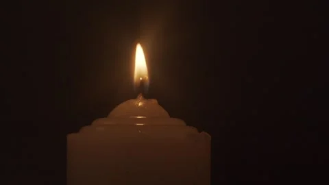 Close-up of Burning White Candle Flame Against Dark Background Vídeos de archivo 334643808